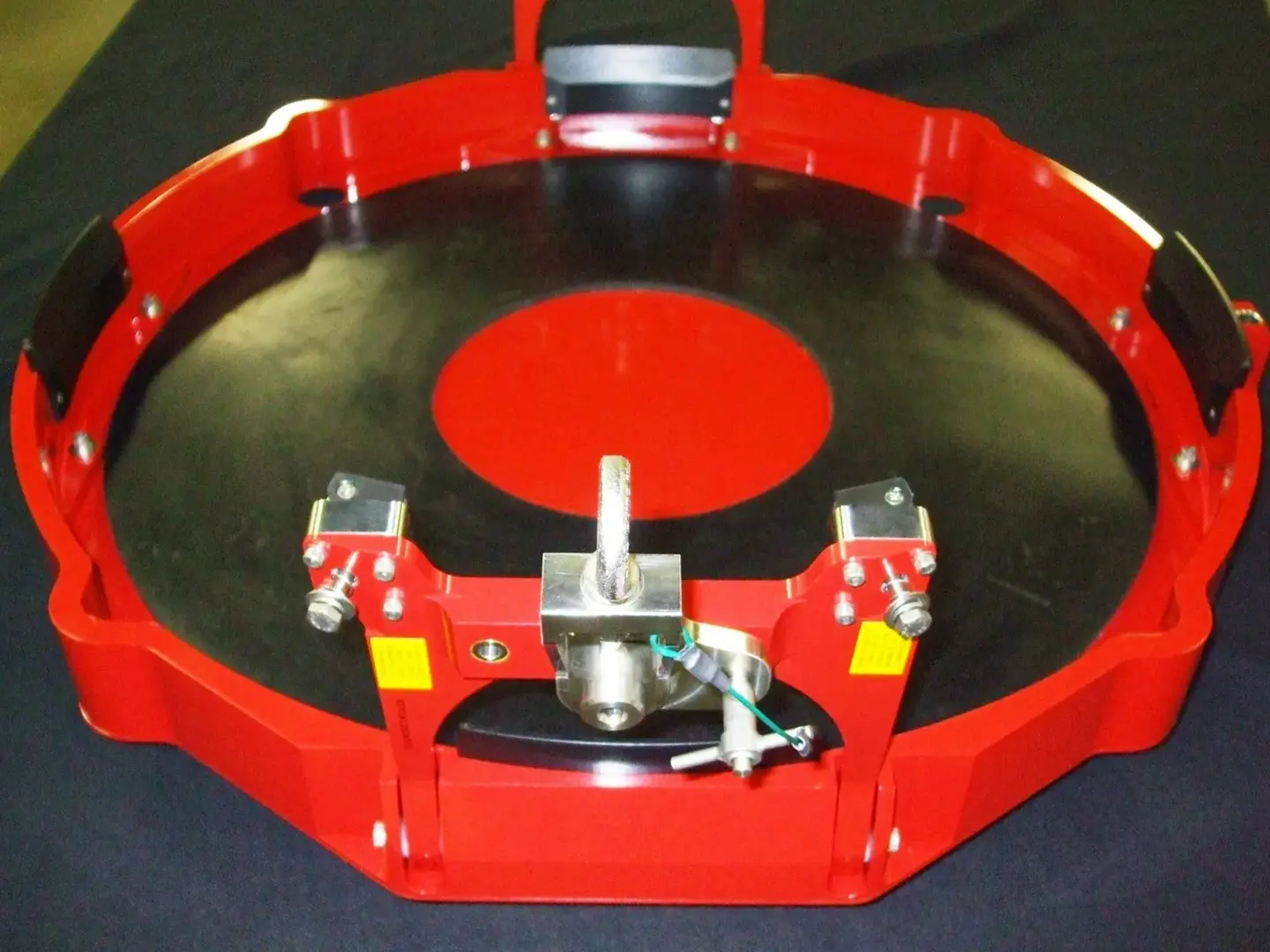 A red turntable with a black record on top.