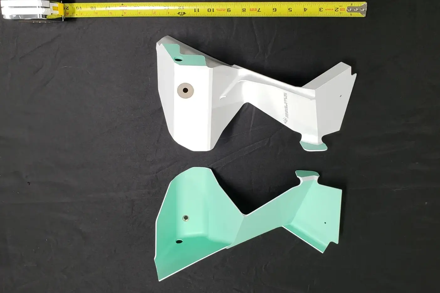 A pair of white and green plastic parts.