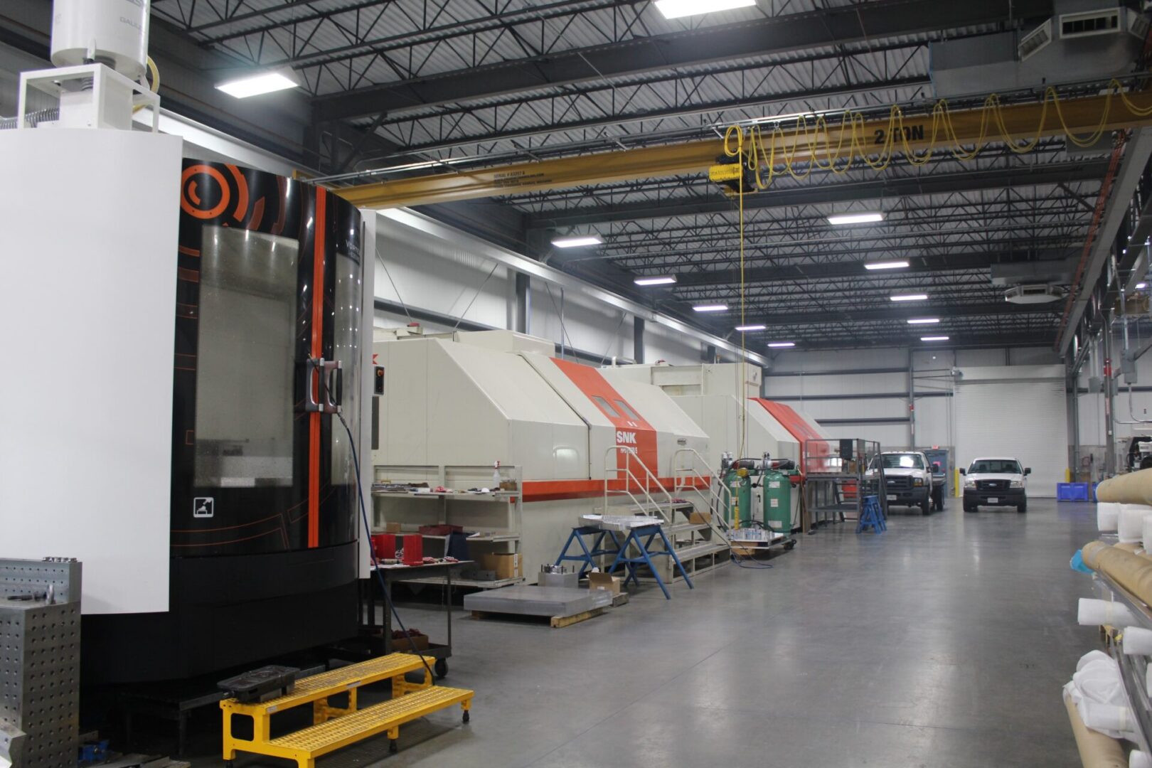 A large warehouse with many vehicles parked in it.