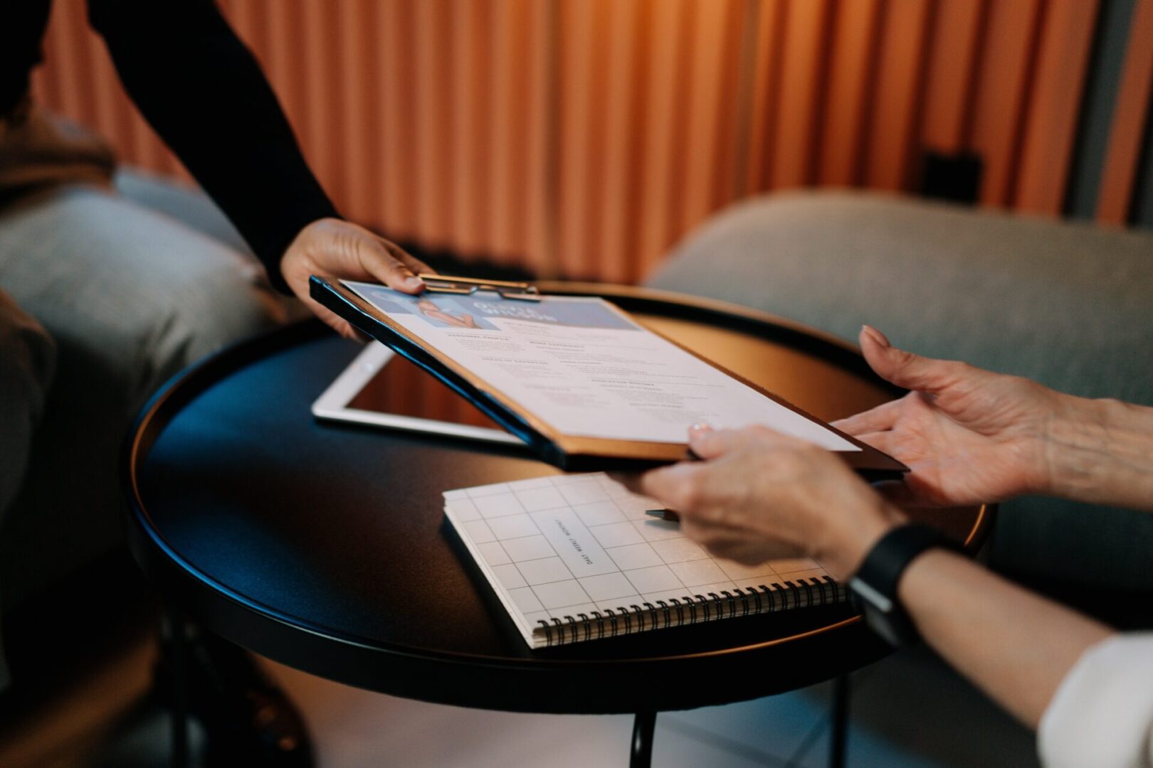 Two people are sitting at a table with papers on it.