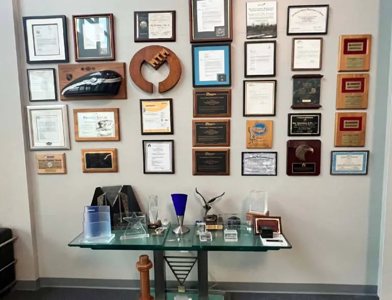 A wall with many awards and trophies on it